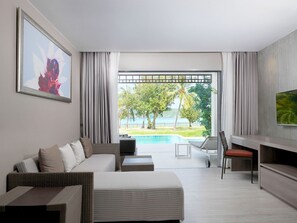 A modern hotel room with a large window, a sofa, a TV, and a pool view. - PP Princess Pool Villa (Ko Phi Phi)