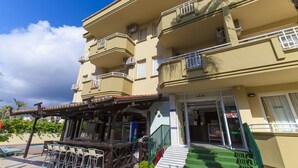 A multi-story hotel with balconies, outdoor seating, and a pool area. - Exelsior Annex (Marmaris)