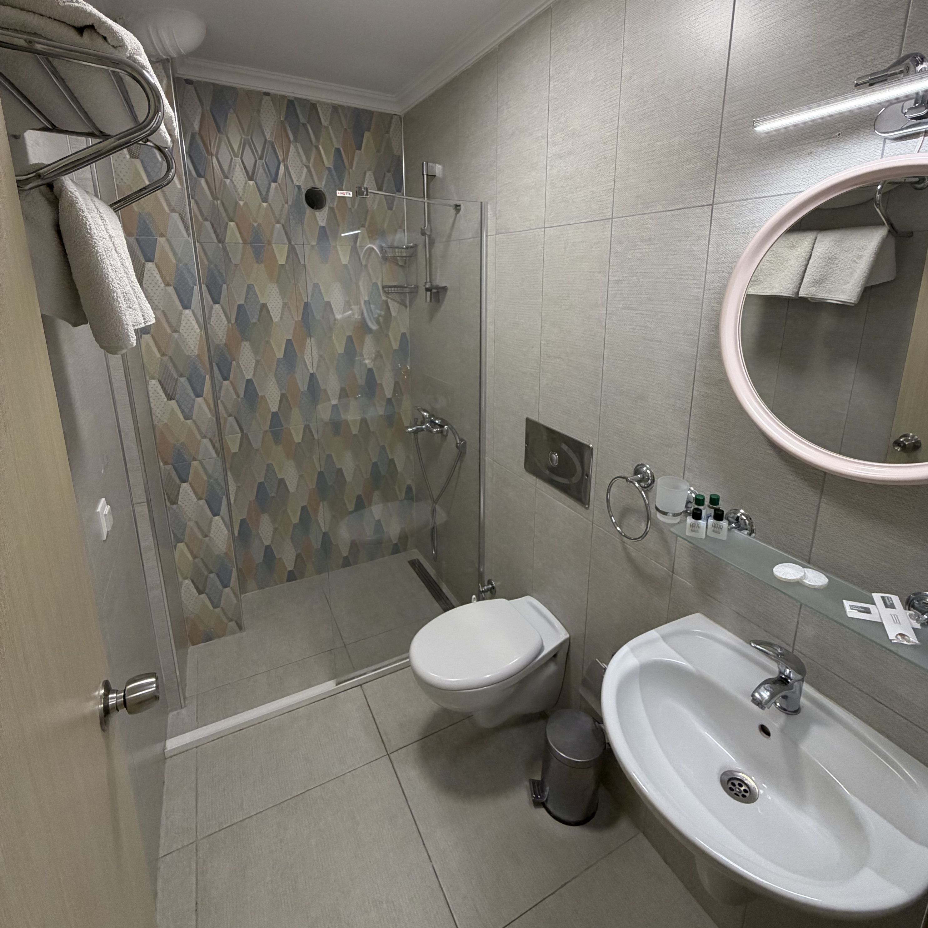 A bathroom with a shower, toilet, and sink.