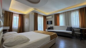 A hotel room with a bed, a sofa, a TV, and a desk. - Arya Apart (Marmaris)