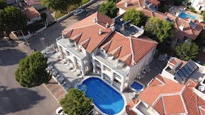 A large building with a swimming pool, multiple balconies, and solar panels. - Arya Apart (Marmaris)