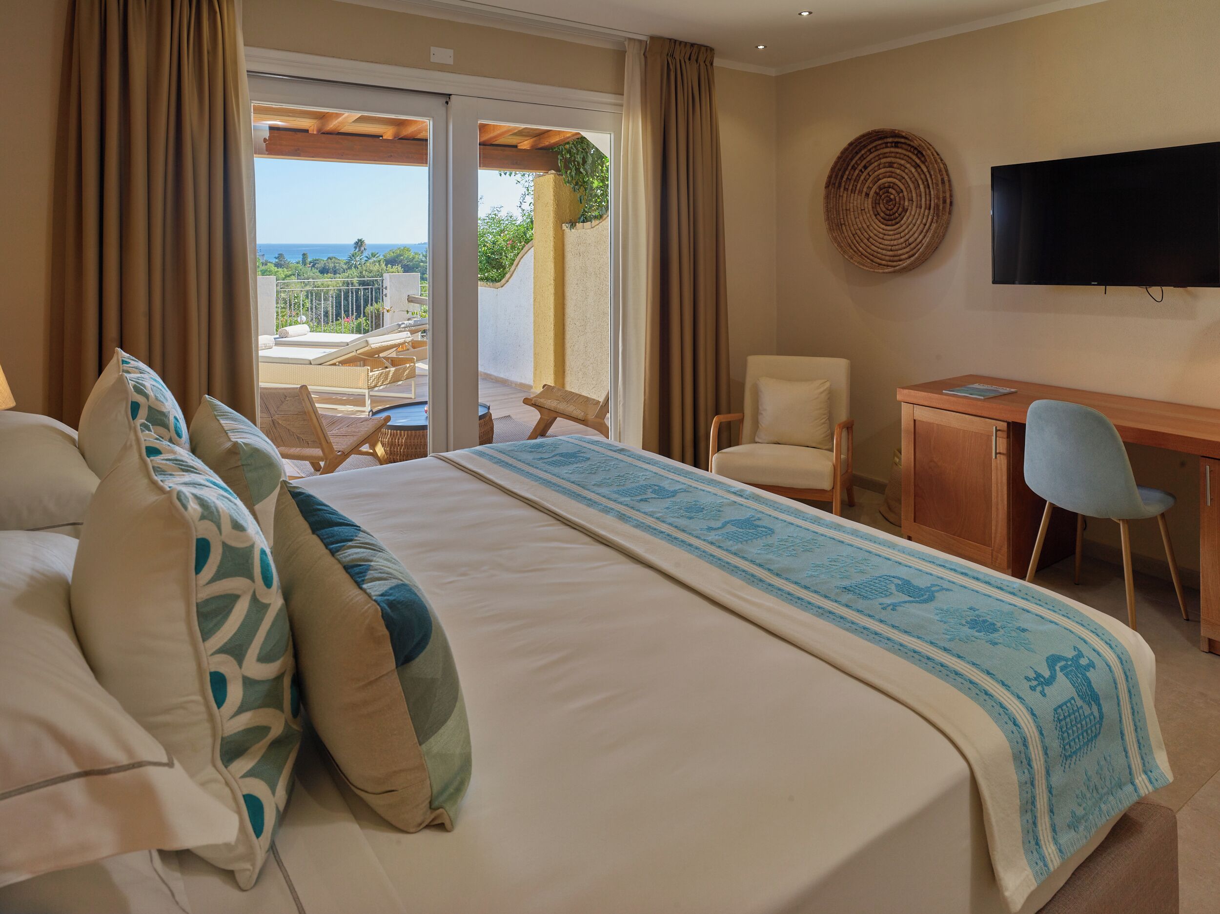 Une chambre d’hôtel équipée d  ’un lit, d’un bureau, d’une chaise, d’une télévision et offrant une vue sur l’extérieur.