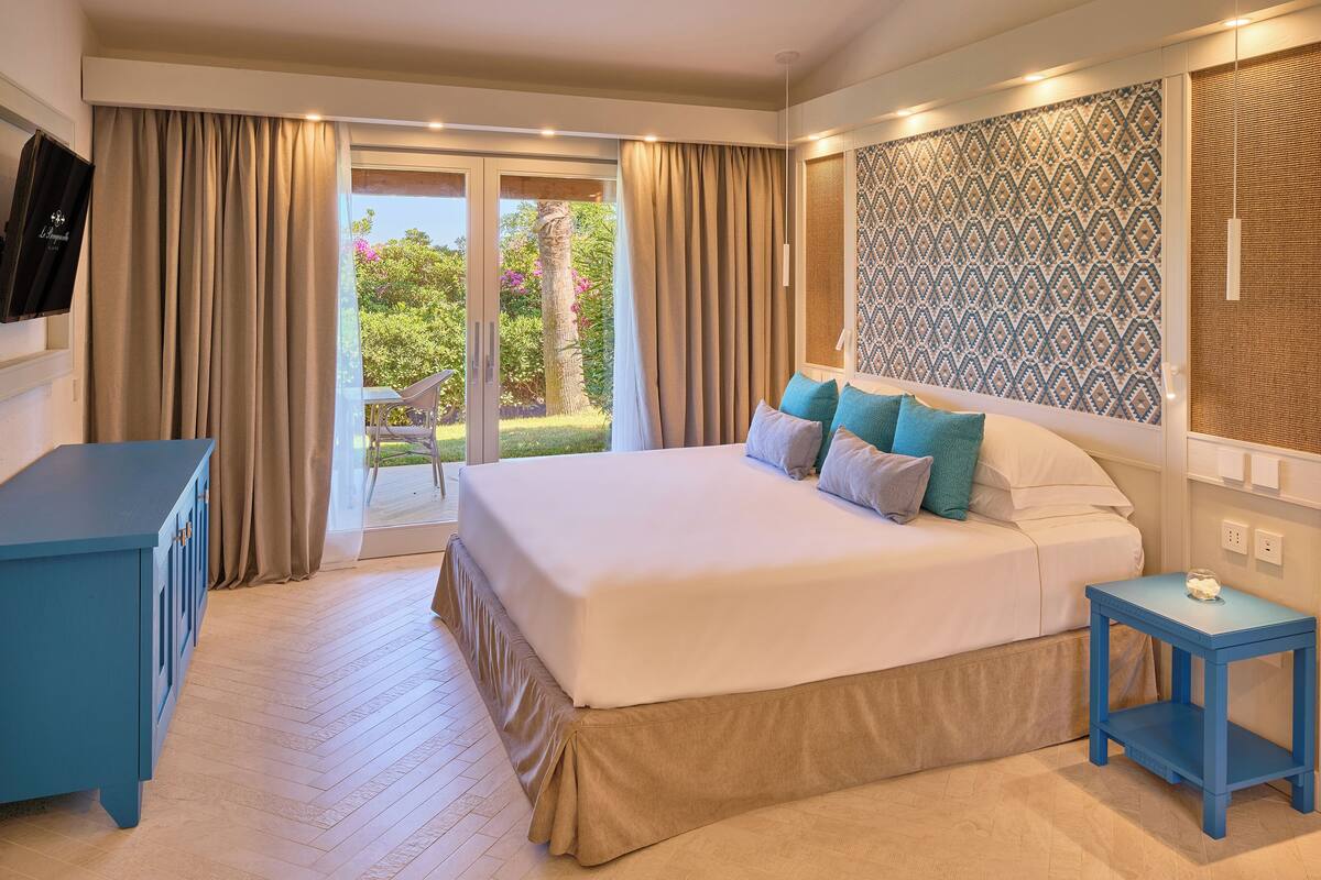 Een hotelkamer met een bed, een bureau en uitzicht op de omgeving.