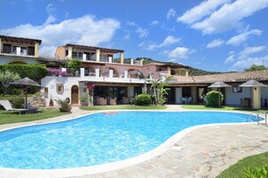 Una piscina al aire libre de temporada, sombrillas