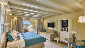 Une chambre d’hôtel avec un lit, un canapé, une télévision, une petite table et une vue sur l’extérieur.