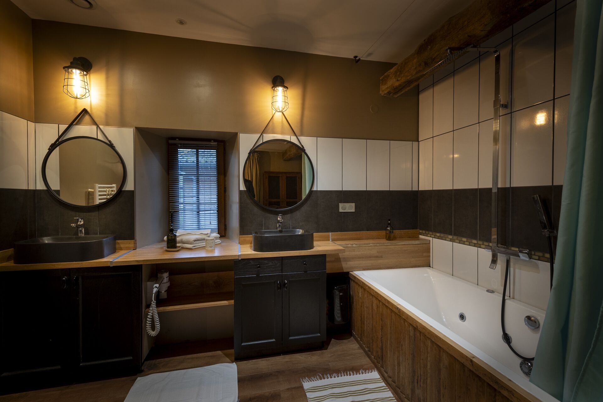A modern bathroom with two sinks, a large bathtub, and a walk-in shower.