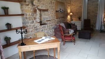Un salón acogedor con pared de piedra, muebles de madera y un candelabro.