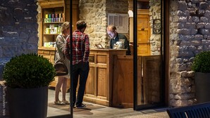 A stone building with a wooden counter and a glass door. - Au Domaine de la Pommeraye & Spa (La Pommeraye)
