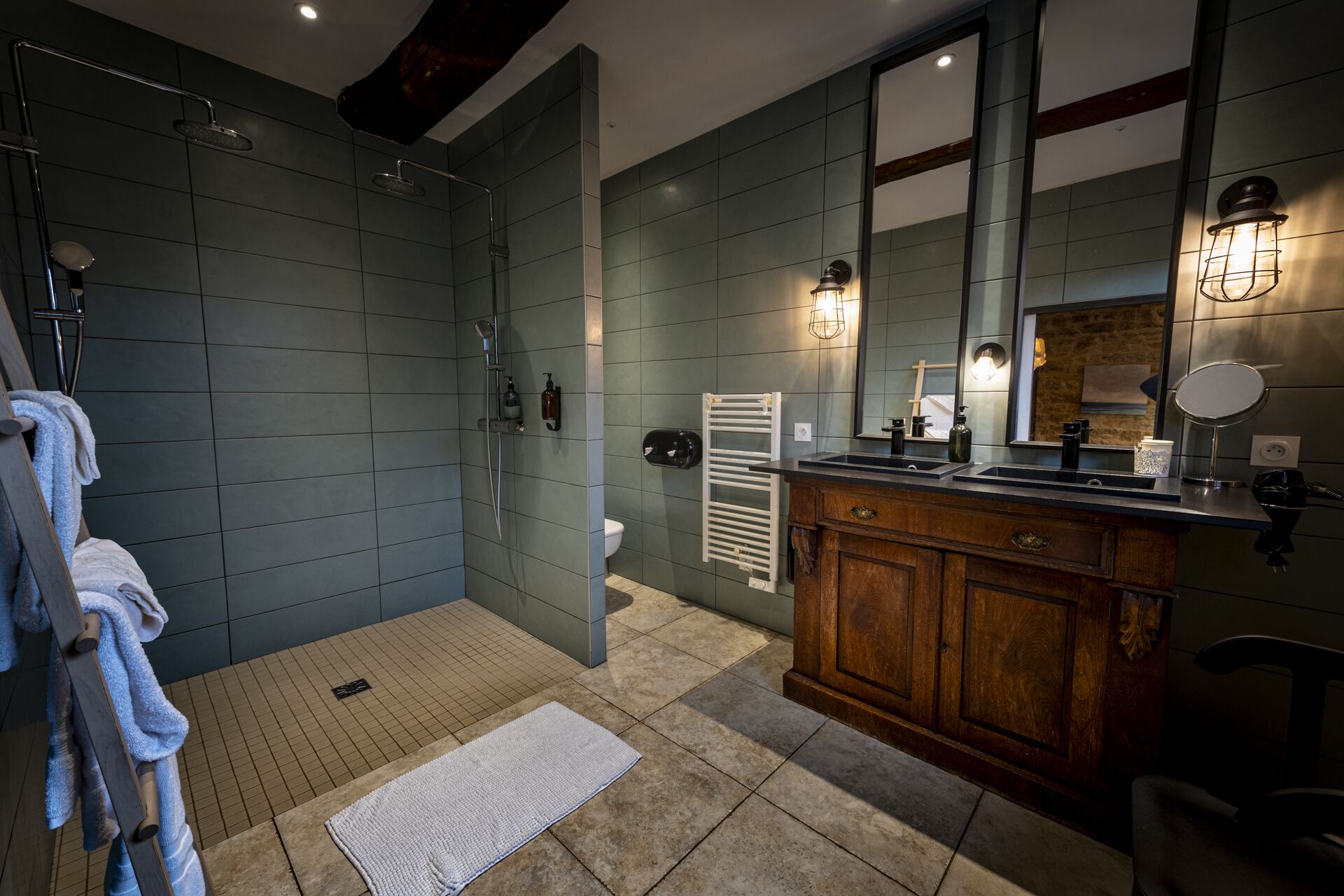 Une salle de bain moderne avec une douche à l’italienne, un meuble-lavabo en bois et un grand miroir.