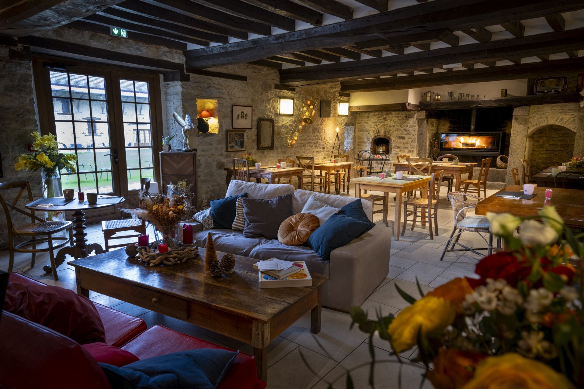 Un interior acogedor con chimenea de piedra, muebles de madera y zona de comedor.
