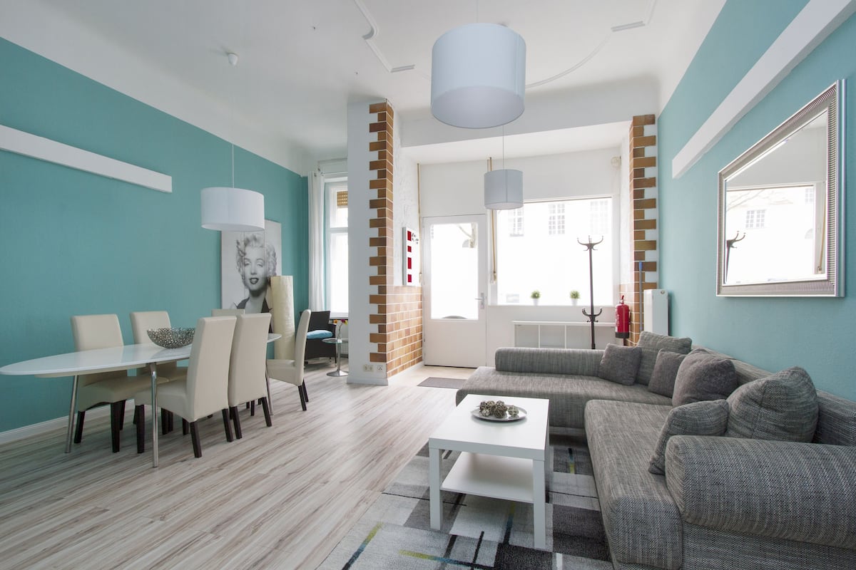 A modern living room with a dining area, a sofa set, and a coffee table.