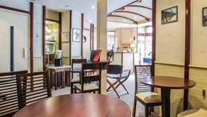 Eine Hotlelloge mit Holzmöbeln, einer Rezeption und gerahmten Bildern an den Wänden.