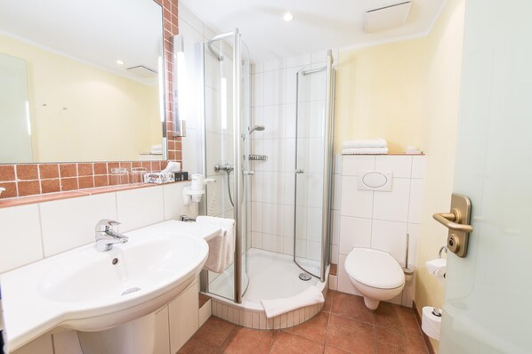 Une salle de bain moderne avec une douche à parois de verre, un lavabo et des toilettes.