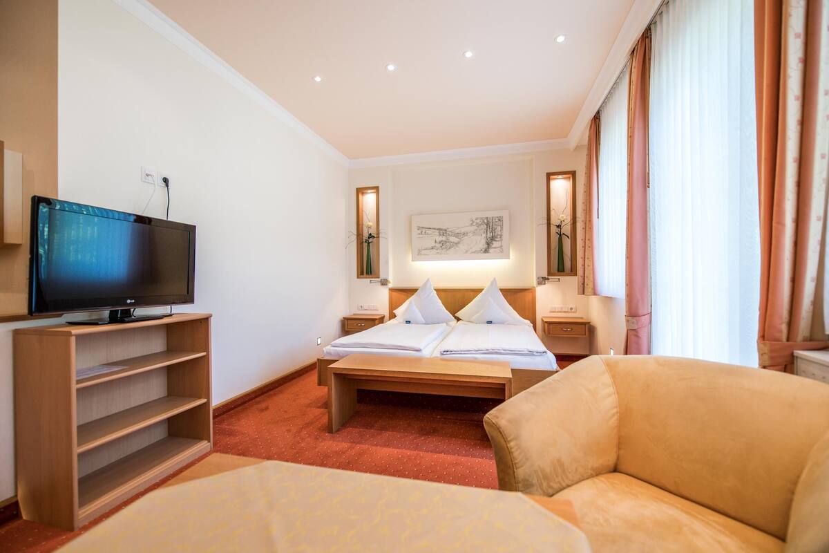 Une chambre d’hôtel équipée d’un lit, d’une télévision, d’un bureau et d’une chaise.