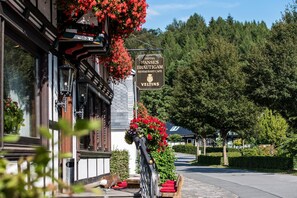A hotel sign with "Hotel Hanses Brautigam Restaurant Cafe Veltins" and a flower-adorned exterior. - Landgasthof Hotel Hanses-Bräutigam (Schmallenberg)