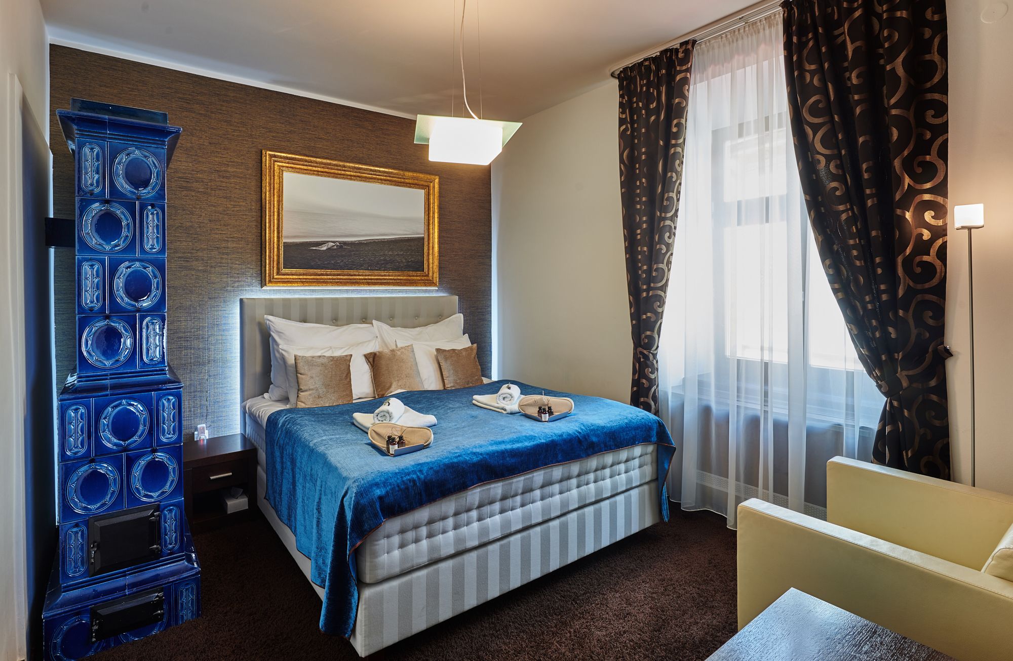Ein Hotelzimmer mit einem Bett, einem Schminktisch, einem Spiegel und einem Fenster mit Vorhängen.
