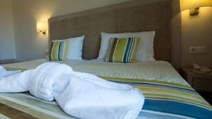 Une chambre d’hôtel avec un lit, une table de chevet et une armoire.