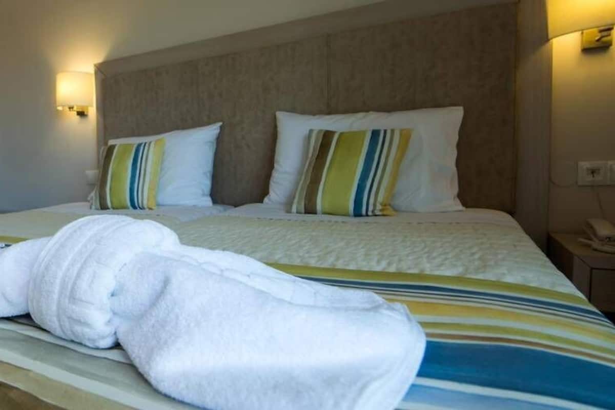 A hotel room with a bed, a nightstand, and a wardrobe.