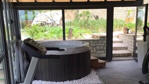 Une salle de sport équipée d’un sauna, de matériel d’exercice et offrant une vue sur l’extérieur.