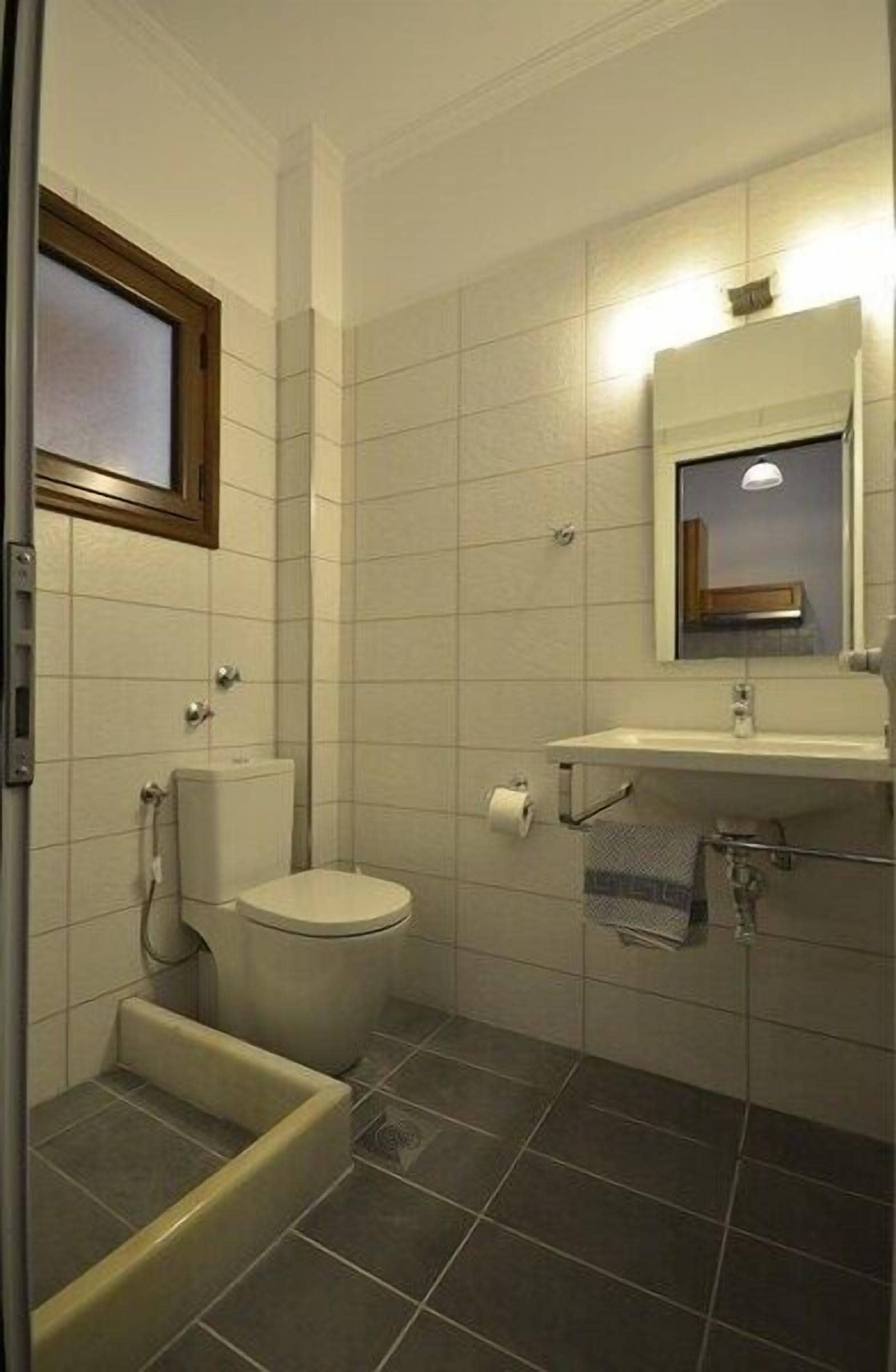 Een badkamer met toilet, wastafel en douche.