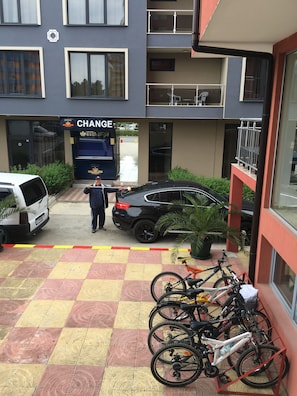Un bâtiment sur lequel est affiché un panneau indiquant « CHANGE » et une zone de stationnement avec des vélos.
