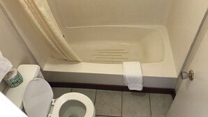 A bathroom with a bathtub, toilet, and a shower curtain. - Parkview Motel (Corning)