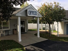 Um pequeno edifício de escritórios com uma placa que diz "OFFICE" sobre a entrada.