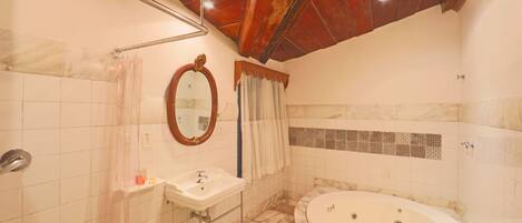 A bathroom with a marble floor, a sink, a bathtub, and a shower with a glass door.