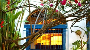 A rustic building with a blue window and a wooden structure in front. - Pousada do Amparo (Olinda)