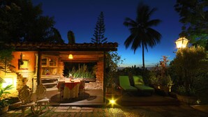 A cozy outdoor patio with a dining area, a fireplace, and lounge chairs. - Pousada do Amparo (Olinda)
