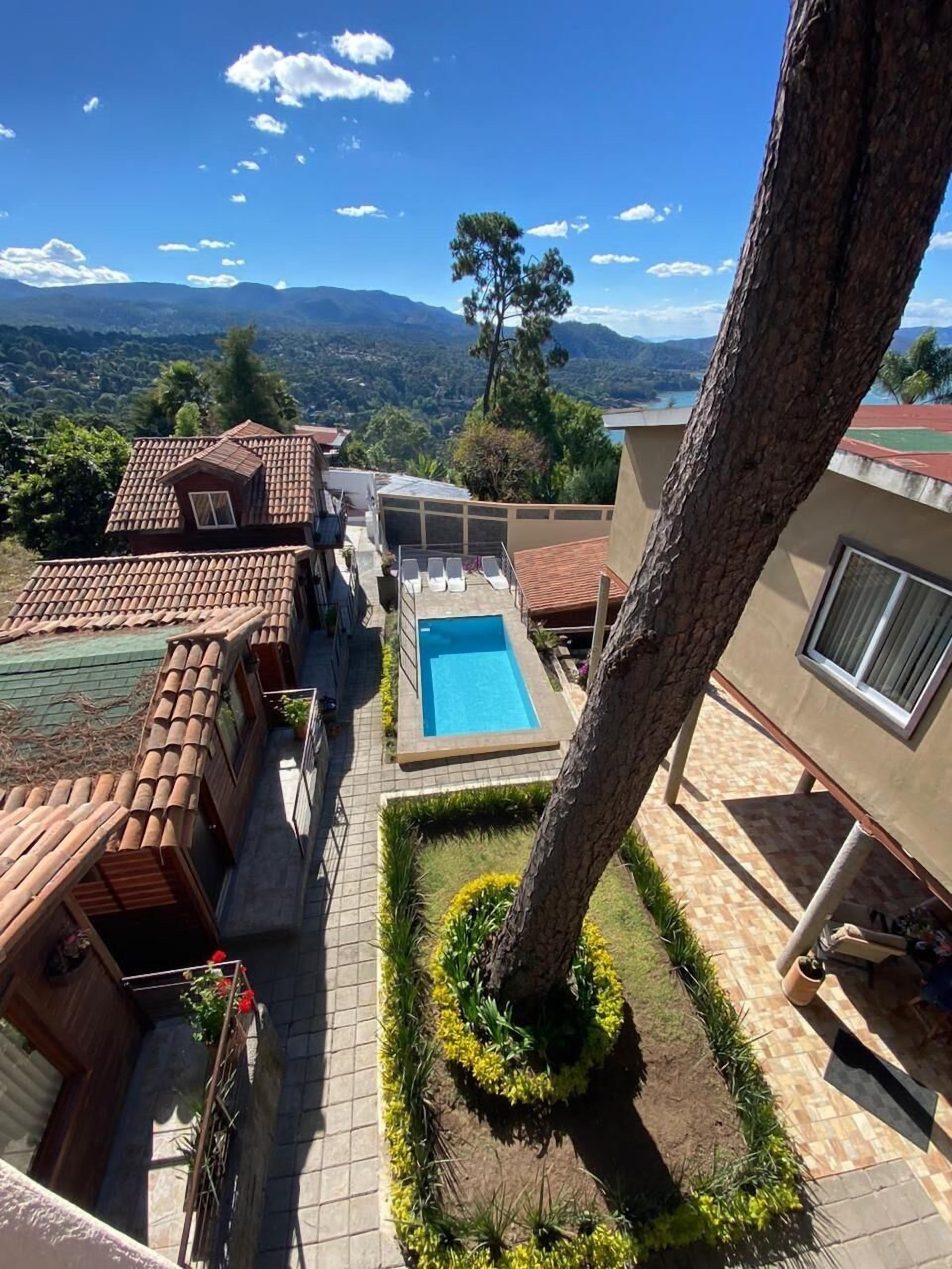 Una propiedad residencial con piscina, vistas a la montaña y un jardín cuidado.