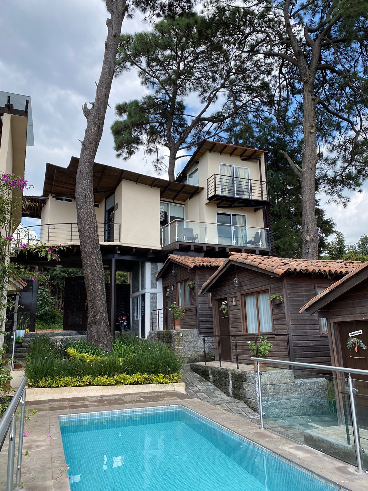 Un edificio de dos pisos con piscina delantera.