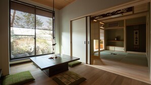 A traditional Japanese room with tatami flooring, a low table, and sliding doors. - CHIKUYOAN (Nagaokakyo)