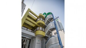 Hotel com design moderno, com várias varandas e uma escadaria imponente.