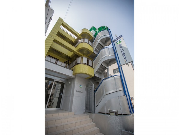 A hotel with a modern design, featuring multiple balconies and a prominent staircase.