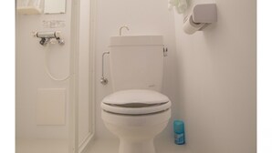 Uma casa de banho branca com sanita, chuveiro e porta-toalhas.