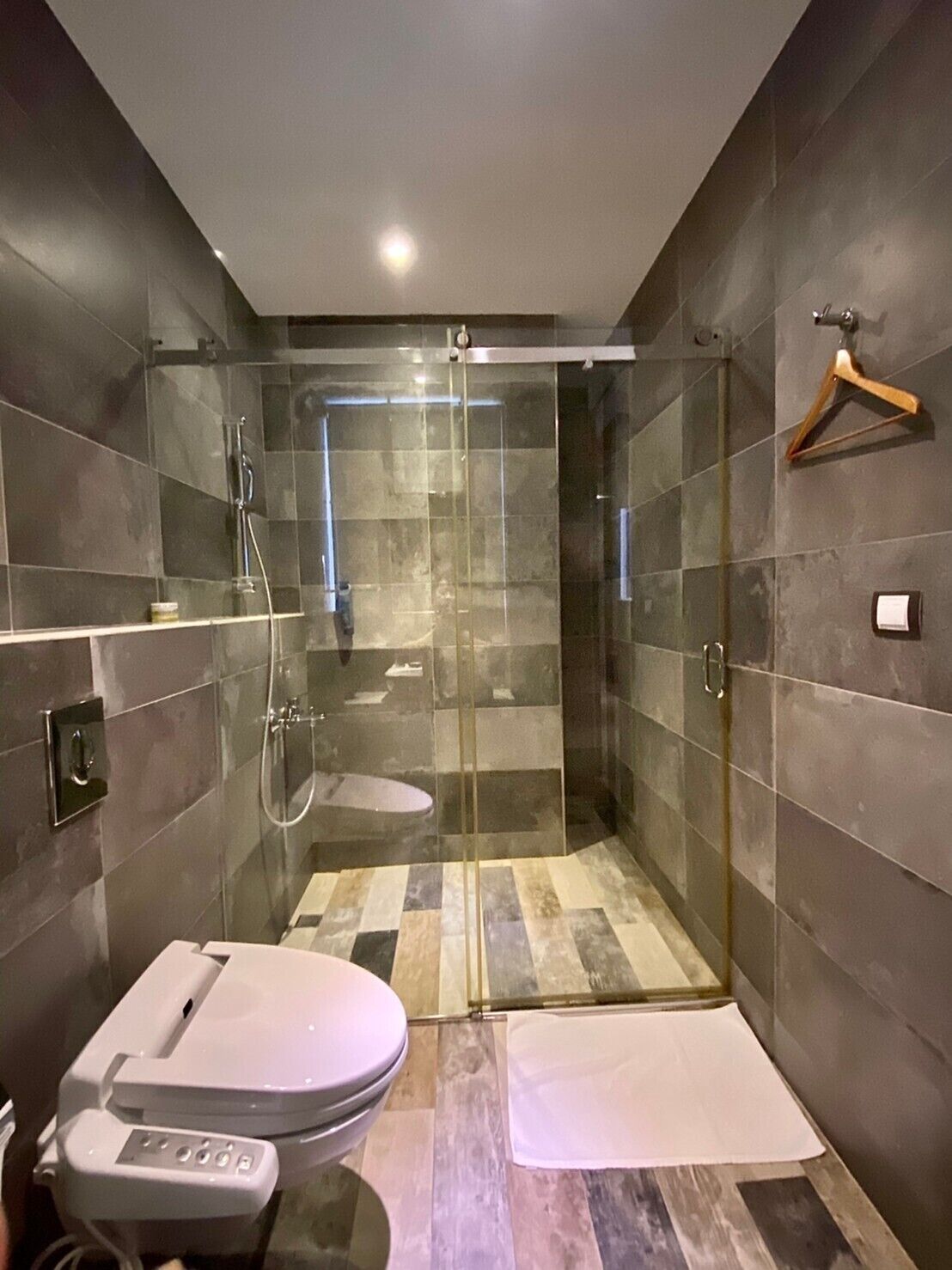 Un baño moderno con ducha envuelta en vidrio, inodoro y bidé.