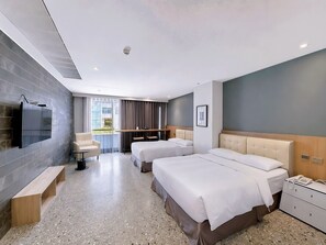 A modern hotel room with a large bed, a smaller bed, a sofa, a TV, a desk, and a window with curtains. - 3 Door Hotel (Tainan)