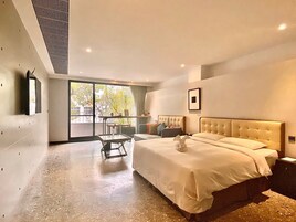 Un dormitorio moderno con una cama grande, una mesa de vidrio y vistas al exterior.