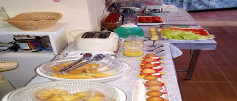 A buffet table with various food items and kitchen appliances.