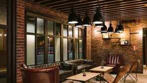A cozy seating area with leather sofas and chairs, a wooden coffee table, and pendant lighting.