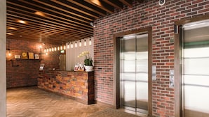 A reception area with a brick wall, wooden ceiling, and a herringbone floor.