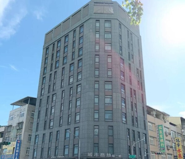 A multi-story building with a modern architectural design, featuring a series of windows and a flat roof.