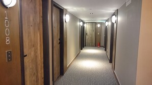 A hallway with wooden doors, numbered 1008, leading to rooms.