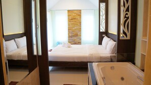 A hotel room with two beds, a large bathtub, and a decorative wall. - Chanpraya Resort (Chanthaburi)