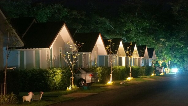 A row of houses with sloped roofs and small front yards, each with a car parked in front. - Chanpraya Resort (Chanthaburi)