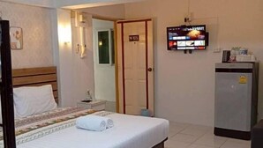 A hotel room with a bed, a television mounted on the wall, a refrigerator, and a door marked "N105". - Nornnan Hotel (Nan)