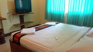 A hotel room with a bed, a television on a stand, and a window with curtains. - Lankham Hotel (Pakse)