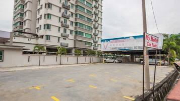 Un hotel de varios pisos con un estacionamiento frente a él.