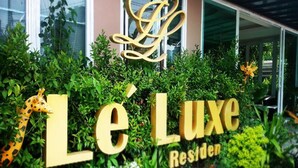 A sign with 'Le Luxe Residences' written in large golden letters, surrounded by lush greenery and a giraffe statue. - Le Luxe Residence (Udon Thani)
